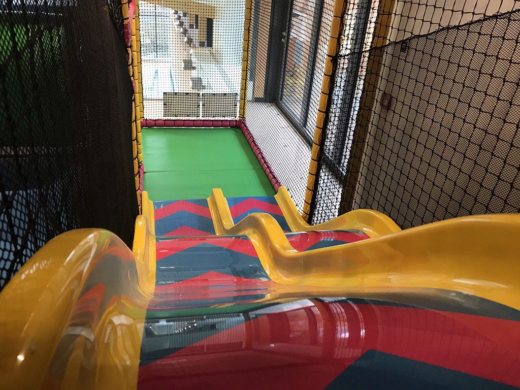 Red, blue and yellow twin lane Astra slide. the photo is positioned at the top of the slides looking down.