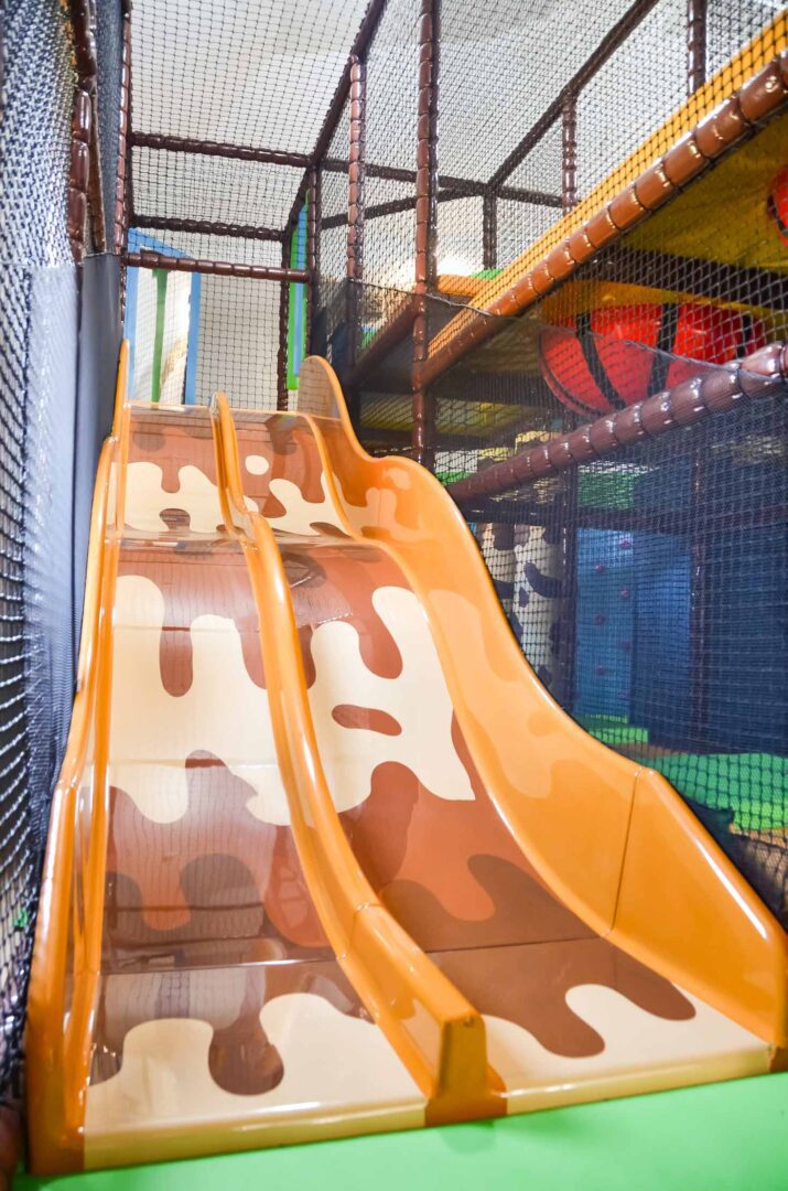 Orange candy-themed twin lane slide at Thorpe Farm.