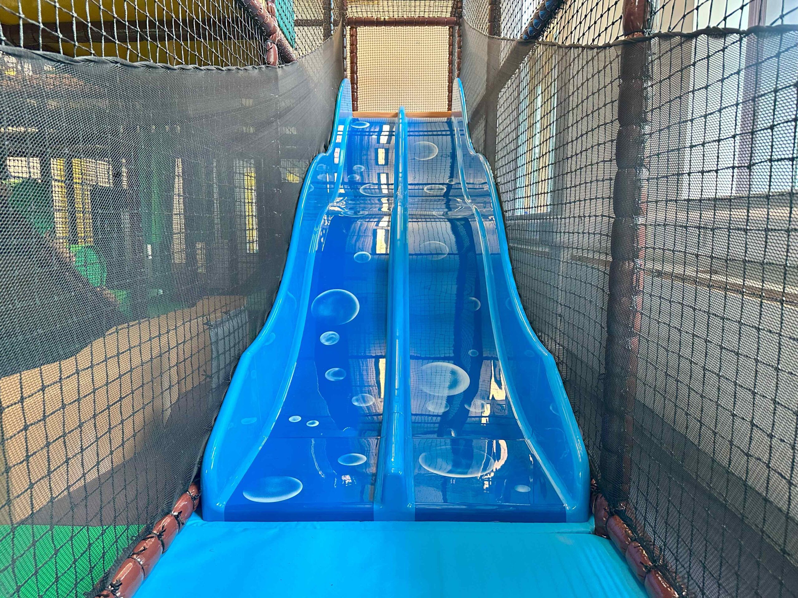 Blue bubble themed 2 lane astra slide found at the Awesome CIC's indoor softplay area, designed by Play Creations.