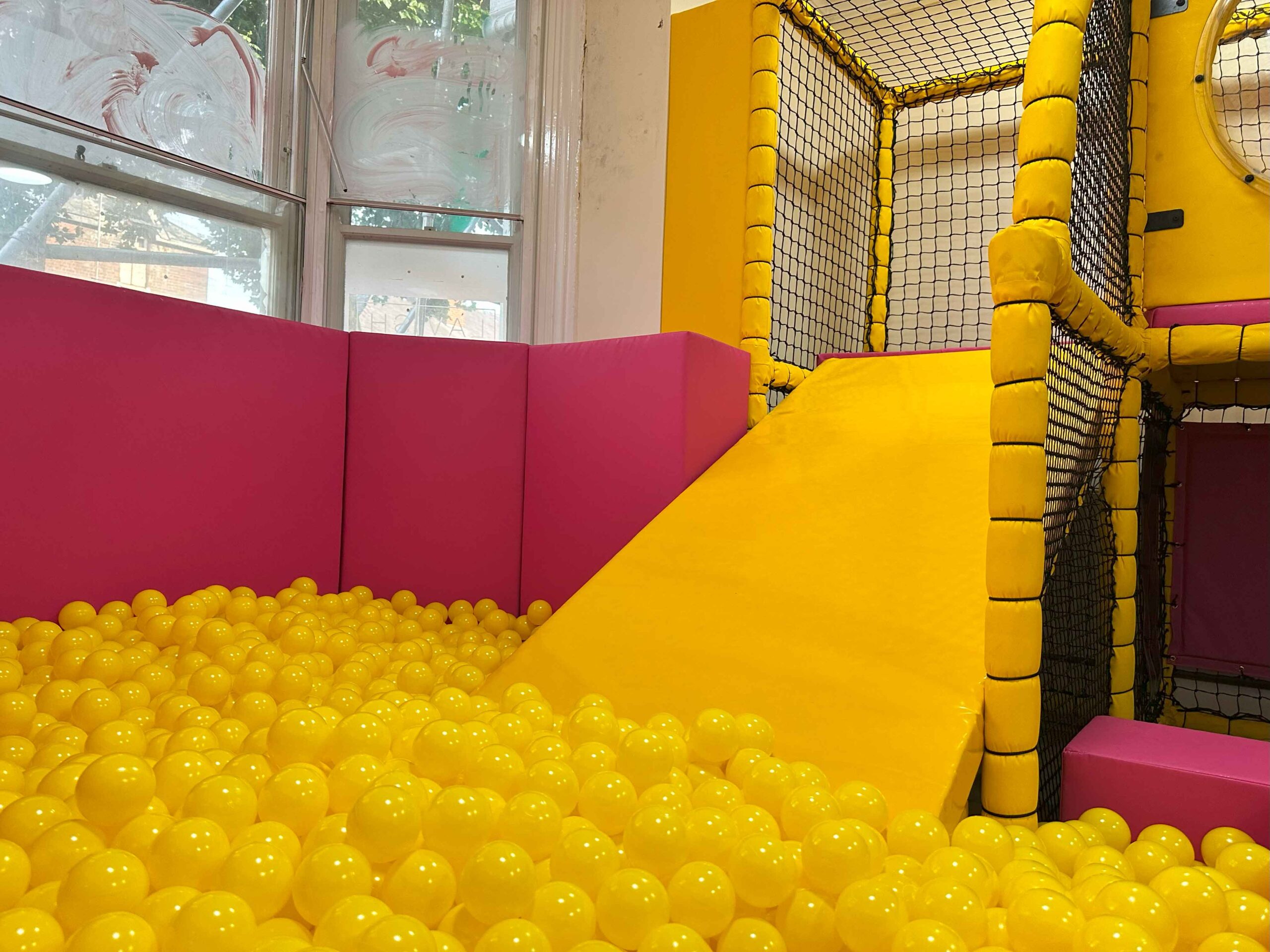 Yellow slide into a yellow ball pit found at the Our Special Angels indoor softplay area in Walsall.