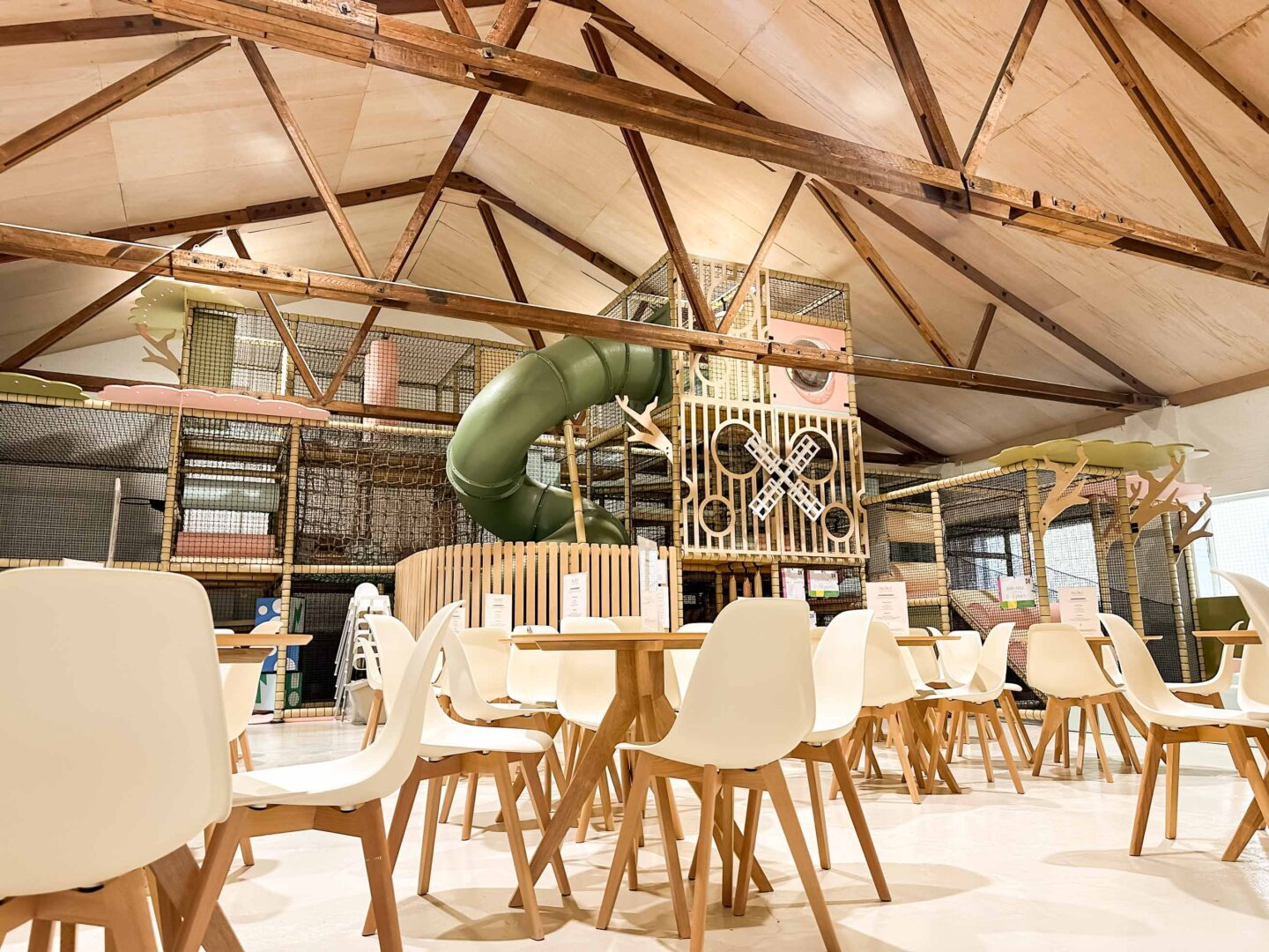 Play Hut's Multi-level indoor softplay. Scandi-Chic theme with soft green and pink colours. There's a large green tube slide and bespoke wooden decorative panelling. Designed by Play Creations