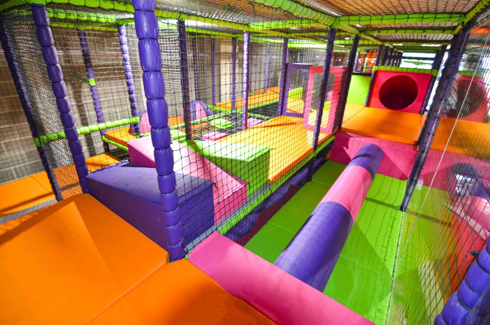 Pink and purple log roller in Colindale's multi-colour soft play area.