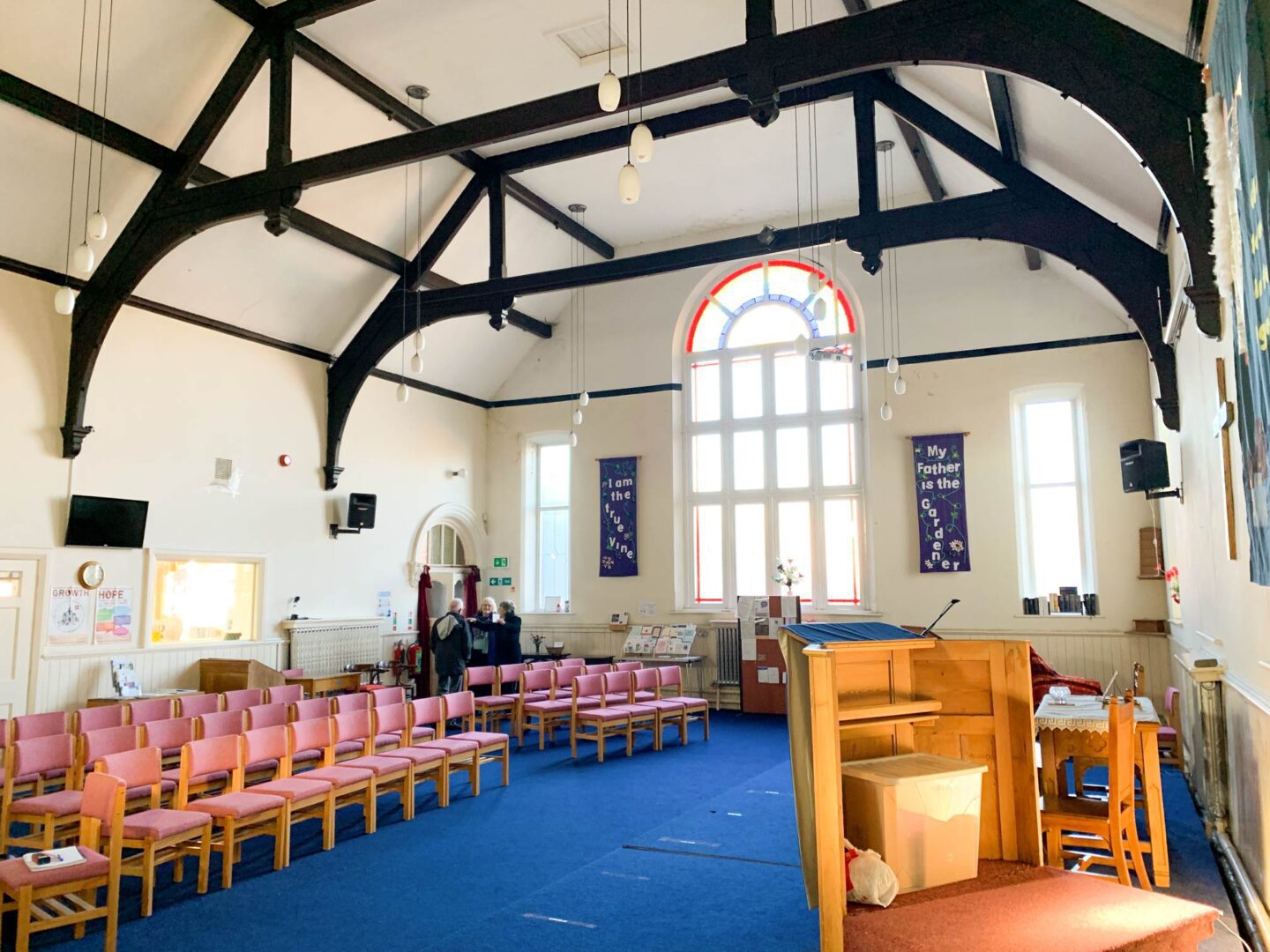 Hemsworth Methodist Church before the softplay installation. There are rows of chairs, a grand window and a wide open space.