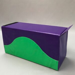 Play Creations' portable softplay retainer block in green and purple with the green sweeping halfway up the block like a hill. View from the side