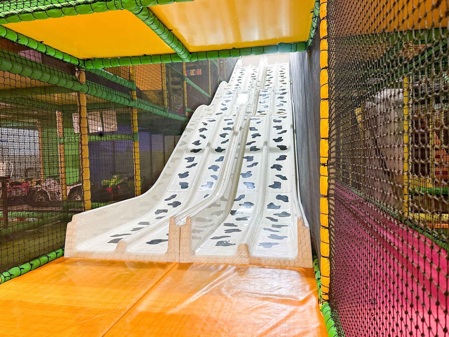 Custom white and black Cow Print 4 Lane Astra Slide for Cannon Hall Farm's indoor softplay area designed by Play Creations.