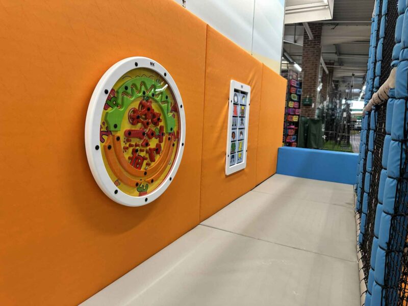 Interactive Wall Game on orange wall panel designed by Play Creations at Downtown Stores indoor softplay area