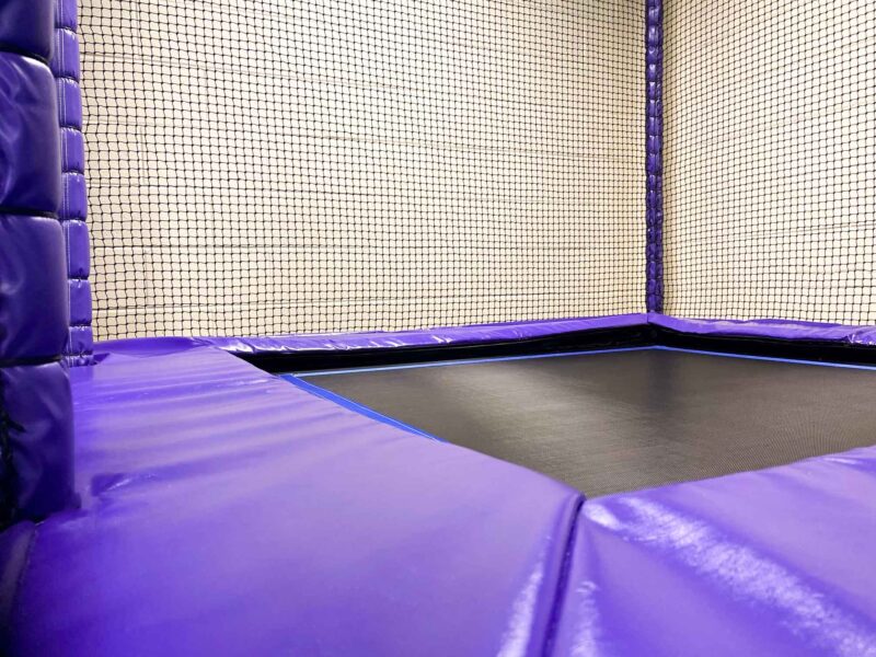 Trampoline encased in purple vinyl padding and netting at St Giles School