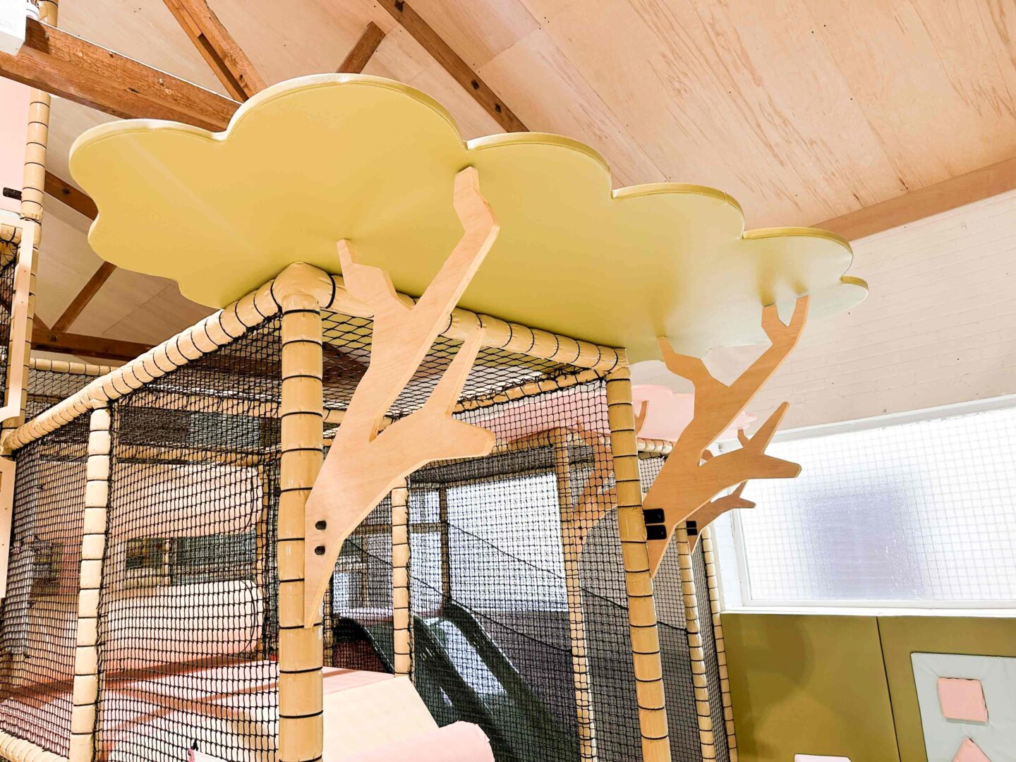 The Play Hut indoor softplay bespoke timber decorative features including two timber tree trunks and a timber cloud shaped leaf designed fitted with LED lighting. This was designed by Play Creations