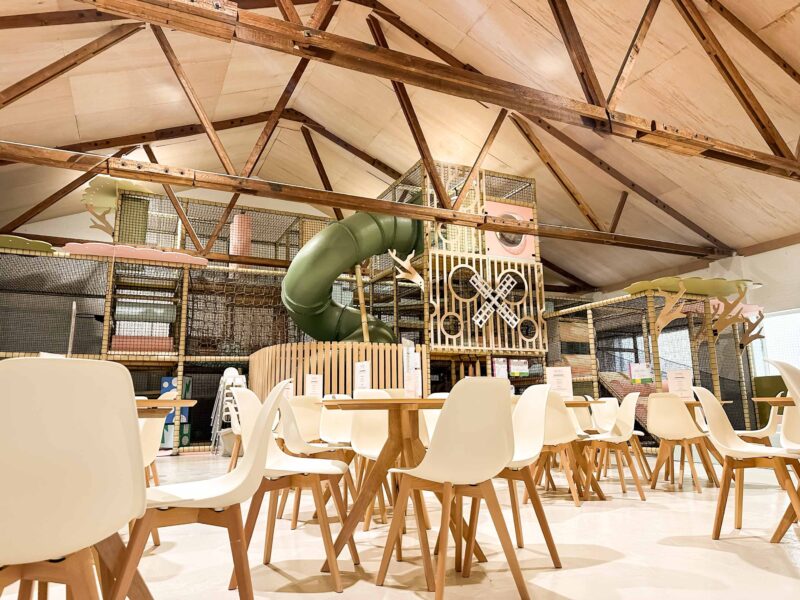 Play Hut's Multi-level indoor softplay. Scandi-Chic theme with soft green and pink colours. There's a large green tube slide and bespoke wooden decorative panelling. Designed by Play Creations