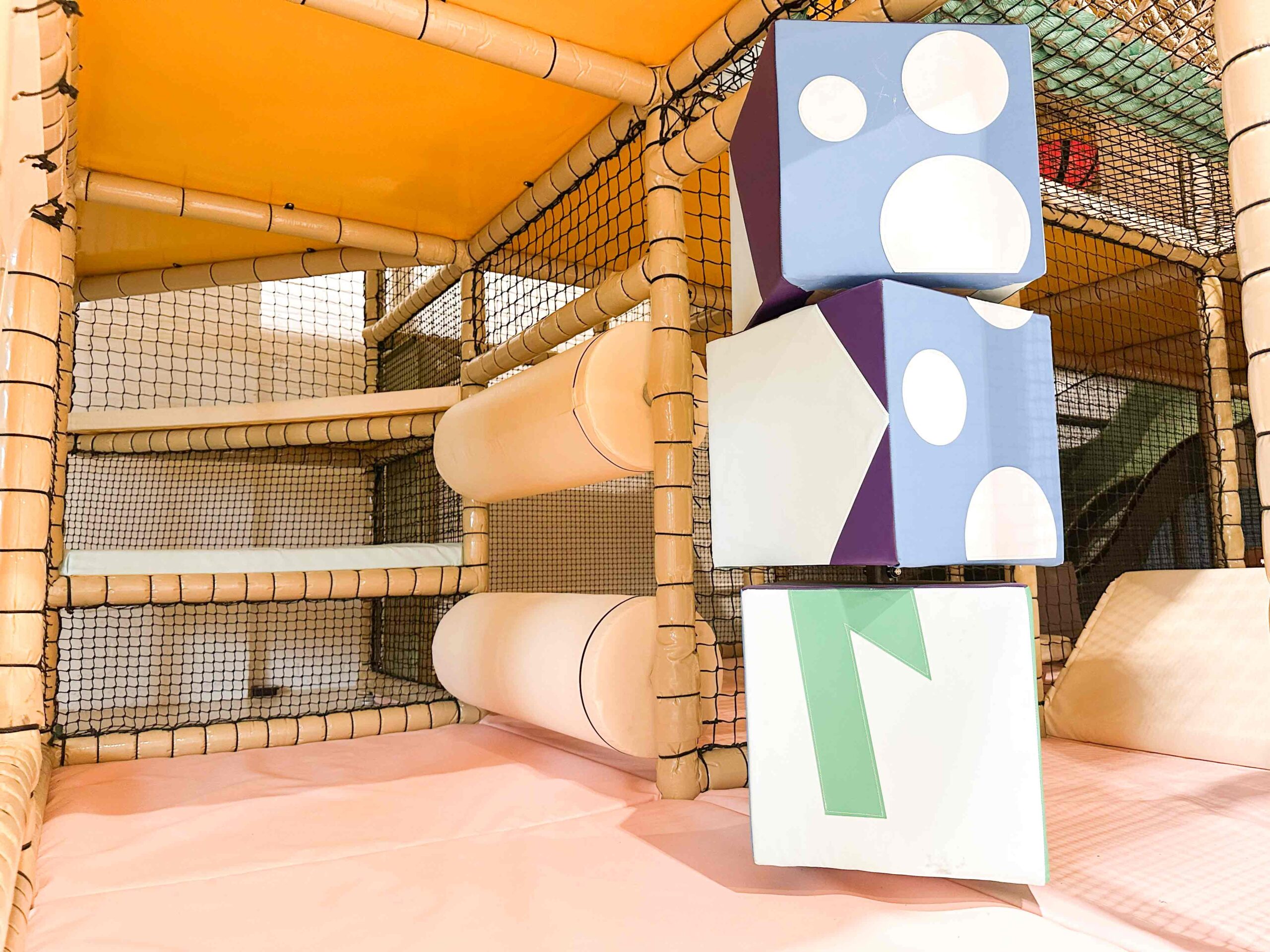 The Play Hut's indoor softplay featuring the colourful bespoke totem pole and beige horizontal rollers. These were both designed by Play Creations