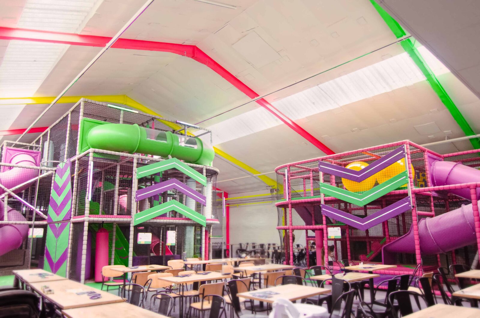 Fun Factory's multi-level indoor play area. Featuring a green, pink and purple softplay, toddler area and baby area. The indoor play area features bright LED arrows.
