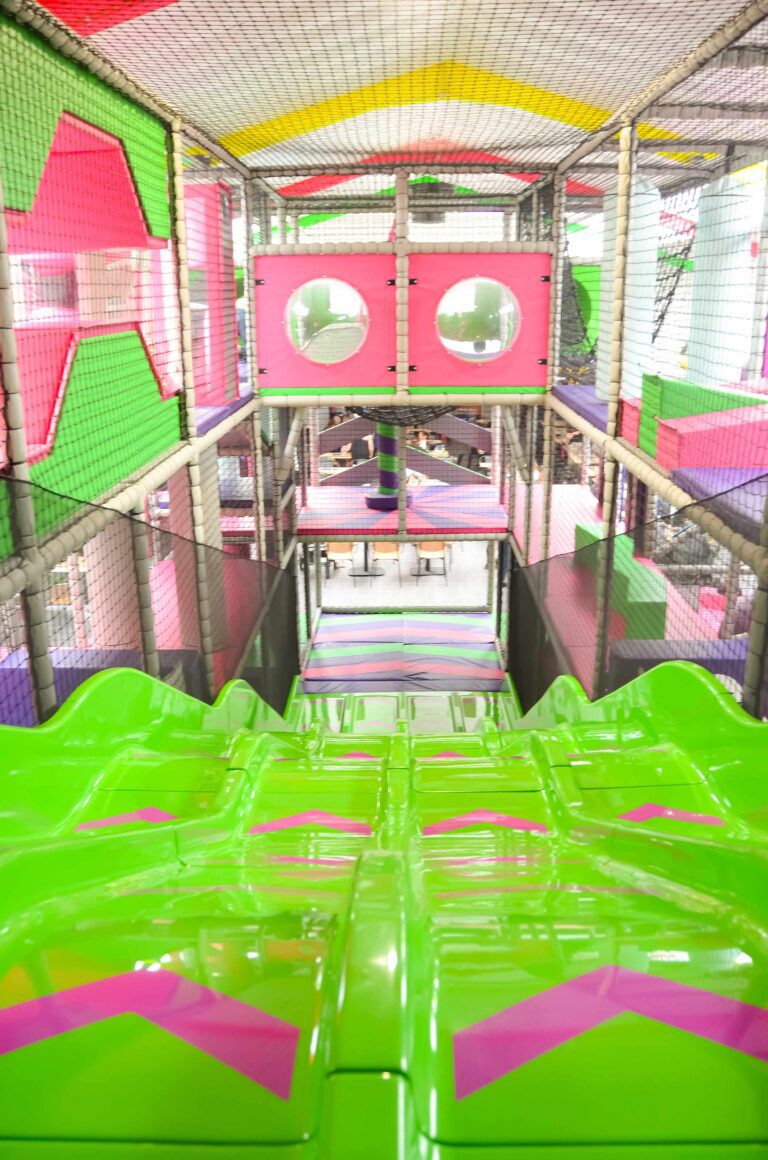 This is the top of the 4 Lane Astra slide overlooking the entire softplay from the inside. The slide is green and pink and overlooking is 2 dome windows so kids can watch people go down the slides.