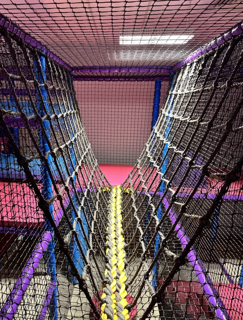 Black and yellow rope bridge at RAF Lakenheath's indoor softplay area designed by Play Creations.