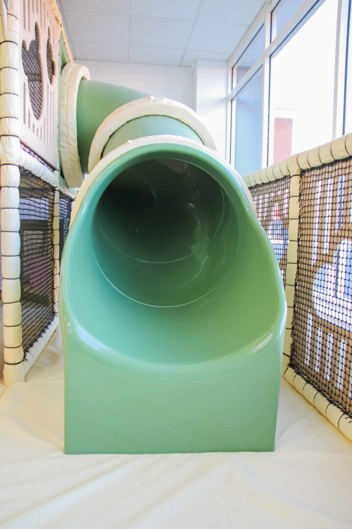 Green tube slide at Cub and Cup Play Cafe